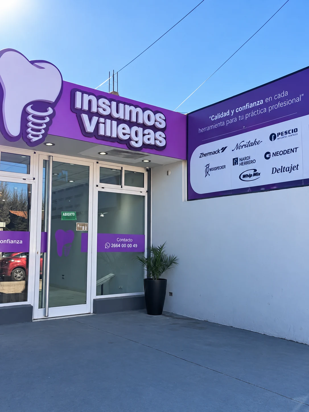 Frente de Villegas Insumos de día, con la entrada y el panel de marcas visibles